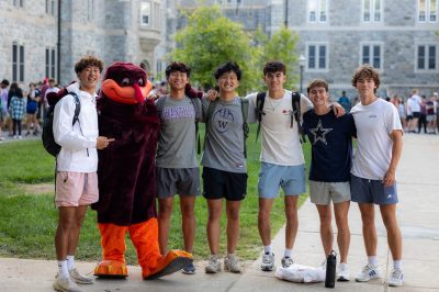 Six men pose for a photo with the HokieBird
