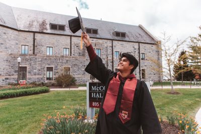 Manolo throwing his graduation cap in the air